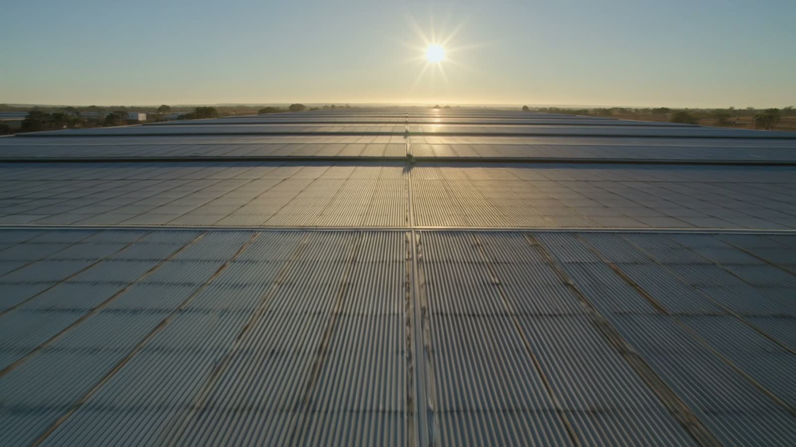 First light across the corrugated steel roof of a large distribution warehouse